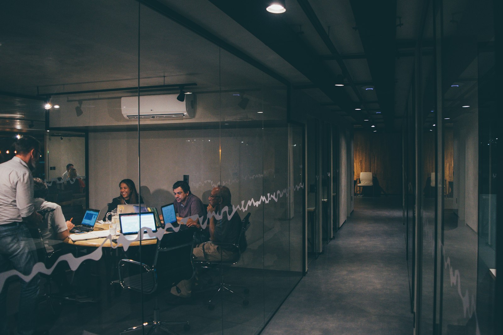 Profesionales colaborando alrededor de una mesa en un entorno corporativo